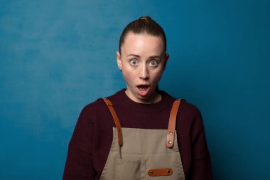 Şok olmuş ya da şaşırmış görünüyor, ağzı açık bakıyor ve 