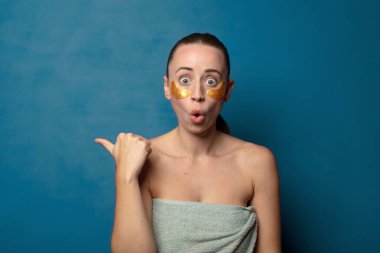 İnançsızlıktan şaşkın şaşkın bakıyor, yan taraftaki objeyi işaret ediyor ve 