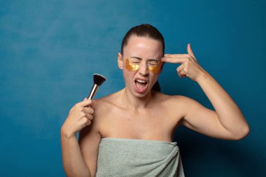 Mutsuz ve stresli görünüyor, intihar jesti elle silah işareti yapıyor, kafasını işaret ediyor.