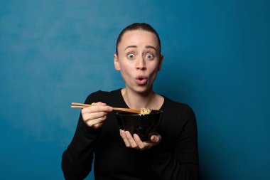 Sarışın, genç, güzel aşçı kadın elinde ramen kasesiyle