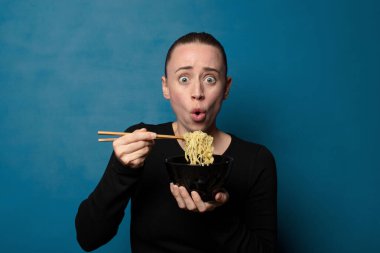 Sarışın, genç, güzel aşçı kadın elinde ramen kasesiyle