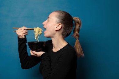 Sarışın, genç, güzel aşçı kadın elinde ramen kasesiyle