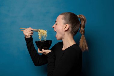Sarışın, genç, güzel aşçı kadın elinde ramen kasesiyle