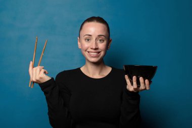 Sarışın, genç, güzel aşçı kadın elinde ramen kasesiyle