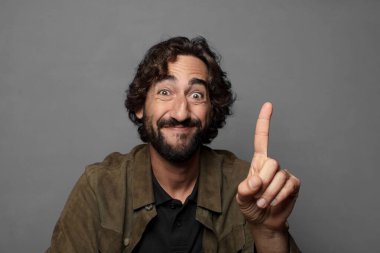 Gururla ve kendinden emin bir şekilde gülümseyerek bir numaralı pozu vererek, bir lider gibi hissederek.