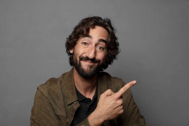 Neşeli bir şekilde gülümseyen, mutlu hisseden, kenarı ve yukarıyı gösteren, kopya uzayda nesneleri gösteren