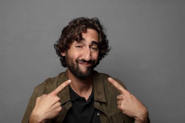 Kibirli ve agresif görünen, yukarıyı gösteren ya da ellerinle alay eden bir tavır takınarak.