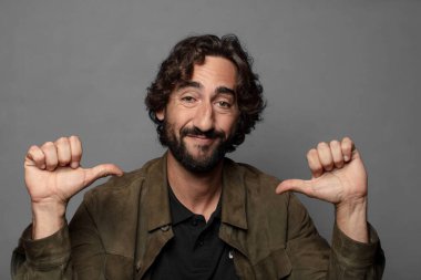 Gururlu, kibirli ve kendinden emin, tatmin olmuş ve başarılı görünüyor, kendini işaret ediyor.