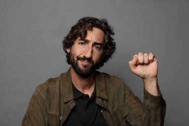 Ciddi, güçlü ve isyankar hissetmek, yumruk kaldırmak, protesto etmek ya da devrim için savaşmak.