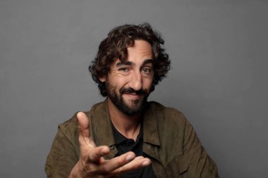 Gülümsüyor, mutlu görünüyor, kendinden emin ve arkadaş canlısı, anlaşmayı bitirmek için el sıkışmayı teklif ediyor, işbirliği yapıyor.