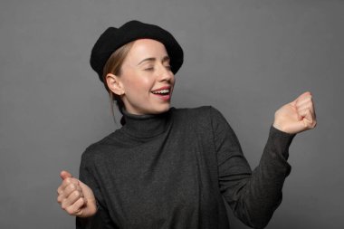 Gülümsüyor, kaygısız hissediyor, rahat ve mutlu, dans ediyor ve müzik dinliyor, bir partide eğleniyor.