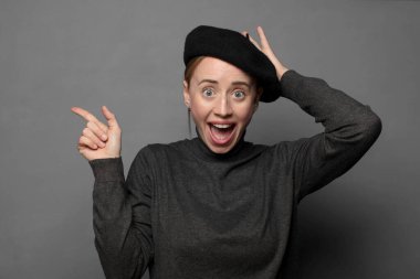 Gülüyor, mutlu, pozitif ve şaşırmış görünüyor. Yan fotokopi alanını işaret eden harika bir fikri fark ediyor.