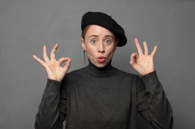 Şaşırmış, şaşırmış ve şaşırmış hissediyorsun. Onayladığını gösteriyorsun. İki elinle de onay imzası atıyorsun.