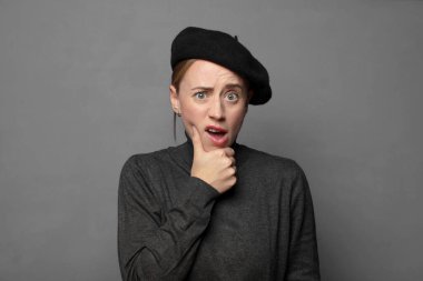 Ağzı ve gözleri açık ve elleri çenesinde, nahoş bir şekilde şokta, ne diyor ya da vay be