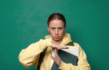 Ciddi görünüyor, sert, kızgın ve hoşnutsuz, mola işareti yapıyor.