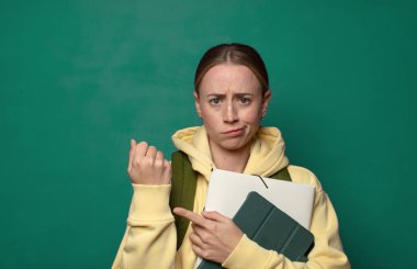 Sabırsız ve kızgın görünüyor, saatine bakıyor, dakiklik istiyor, zamanında gelmek istiyor.