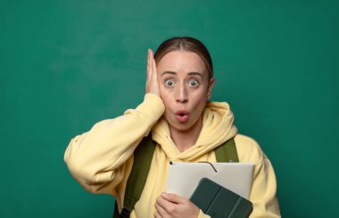 Heyecanlı ve şaşırmış görünüyor, ağzı açık, elleri başının üstünde, şanslı bir kazanan gibi hissediyor.