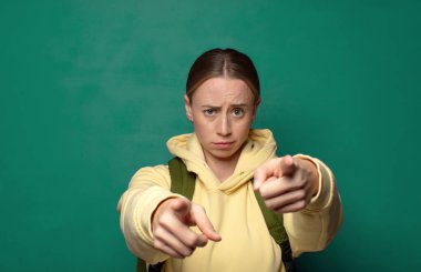 Kamerayı iki parmağınla ve kızgın bir ifadeyle sana görevini yapmanı söylüyor.