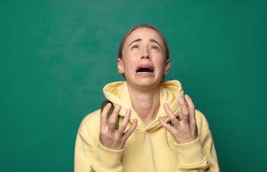 Çaresiz ve hayal kırıklığına uğramış görünüyor, stresli, mutsuz ve sinirli, bağırıyor ve çığlık atıyor