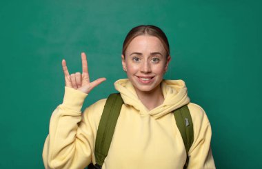 Mutlu, eğlenceli, kendinden emin, pozitif ve isyankar hissediyorum, elle kaya ya da heavy metal işareti yapıyorum.