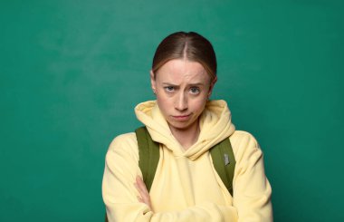 Hoşnutsuz ve hayal kırıklığına uğramış hissediyorum, ciddi görünüyor, kızgın ve çapraz kollara kızgın.