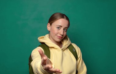 Gülümsüyor, mutlu görünüyor, kendinden emin ve arkadaş canlısı, anlaşmayı bitirmek için el sıkışmayı teklif ediyor, işbirliği yapıyor.