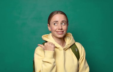 Neşeli bir şekilde gülümsüyor ve yan taraftaki fotokopi alanını işaret ediyor, mutlu ve tatmin olmuş hissediyordu.