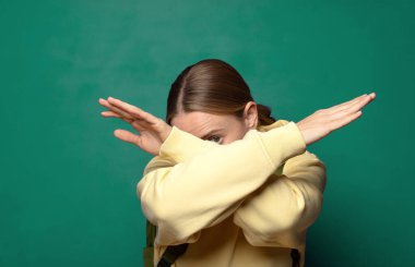 Yüzünü eliyle kapatıyor ve kamerayı durdurmak için diğer elini öne koyuyor, fotoğraf ya da resimleri reddediyor.