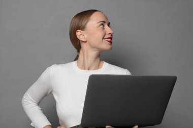 Dizüstü bilgisayarı olan genç sarışın kadın.