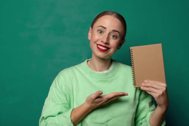 Boş defter kılıfı olan sarışın genç bir kadın.