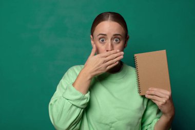 Boş defter kılıfı olan sarışın genç bir kadın.