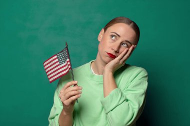 Amerika bayrağı taşıyan genç sarışın kadın.