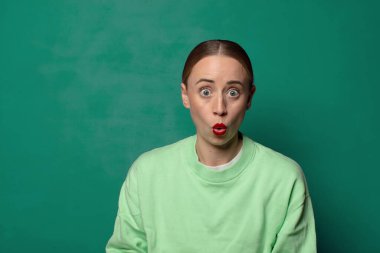 Yeşil stüdyo arka planında fotokopi odası olan genç sarışın kadın.