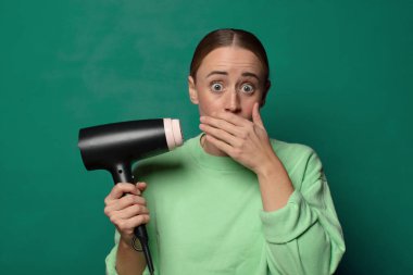 young blonde woman with a hair dryer