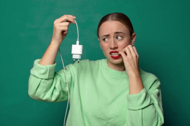 Akıllı telefon şarj aleti olan genç sarışın kadın.