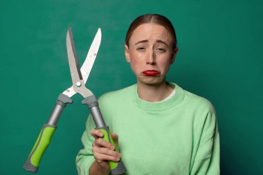 Büyük bir makasla genç sarışın kadın.