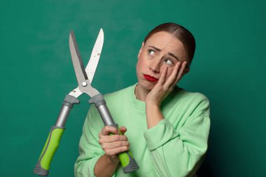 Büyük bir makasla genç sarışın kadın.