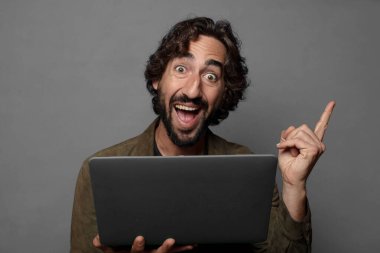 Genç sakallı adam dizüstü bilgisayar kullanıyor.