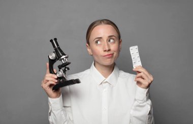 Mikroskop tutan genç kadın bilim adamı