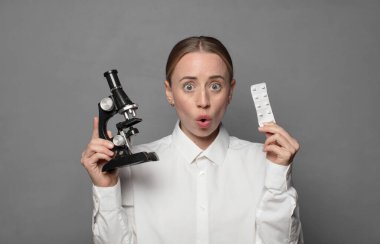 Mikroskop tutan genç kadın bilim adamı