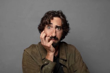 Şok ve inançsızlıkla ağzı açık, elleri yanakları ve kolları çaprazlanmış, sersemlemiş ve şaşkın.