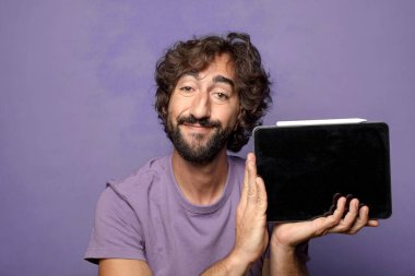 Genç, sakallı, dokunmatik ekranı tutan bir adam.