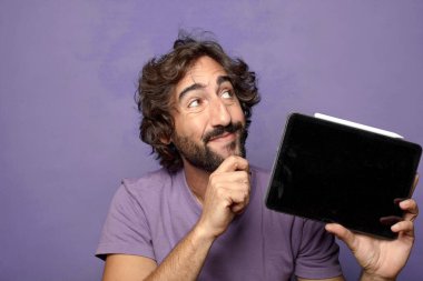 Genç, sakallı, dokunmatik ekranı tutan bir adam.