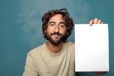 Genç, sakallı, elinde kağıt olan bir adam.