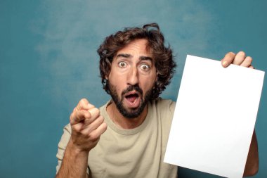 Genç, sakallı, elinde kağıt olan bir adam.