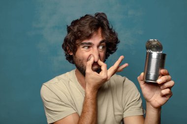 Genç, sakallı, çelik tenekeli adam.