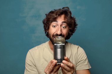 Genç, sakallı, çelik tenekeli adam.