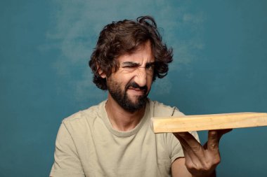 Boş tahta kesim masası olan genç, sakallı bir adam.