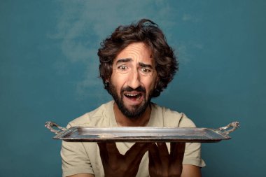 Gümüş tepsisi olan genç, sakallı bir adam.