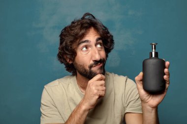 Sabun makinesi olan genç, sakallı bir adam.